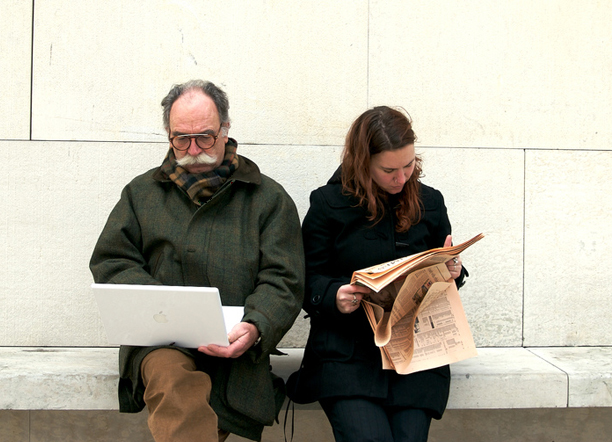 Digital divide: ragazza con quotidiano, anziano con il macbook